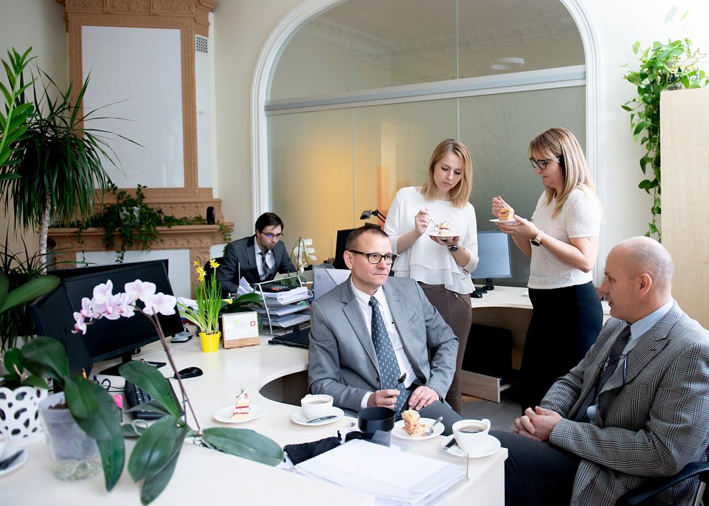 Kollegen machen eine Kaffeepause im Büro an ihrem Schreibtisch.