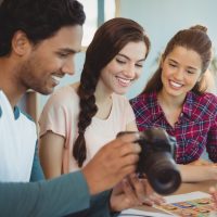 Modedesigner schauen sich Fotos auf einer Digitalkamera im Büro an.